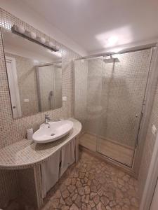 La salle de bains est pourvue d'un lavabo et d'une douche. dans l'établissement AG GUEST HOUSE, à Viterbe