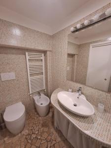 La salle de bains est pourvue d'un lavabo, de toilettes et d'un miroir. dans l'établissement AG GUEST HOUSE, à Viterbe