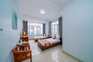 Habitación de hotel con 2 camas y mesa en Sun & Sea Hotel, en Hai Phong