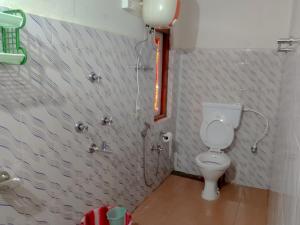 a bathroom with a toilet and a window at The Himalayan Resort in Ravangla