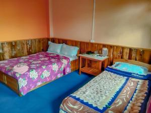 um quarto com 2 camas e uma pequena mesa em The Himalayan Resort em Ravangla
