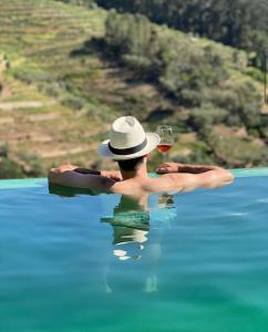 Ein Mann im Wasser, der ein Glas Wein hält. in der Unterkunft Outeiro Douro House in Mártir