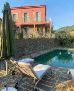a chair and an umbrella next to a swimming pool at Outeiro Douro House in Mártir