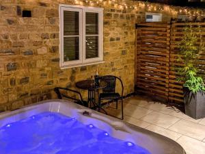 uma banheira num quarto com uma mesa e uma janela em Dovecote em Stoke Bruerne