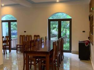 a dining room with a wooden table and chairs at Phong Nha Moonlight Villas in Phong Nha