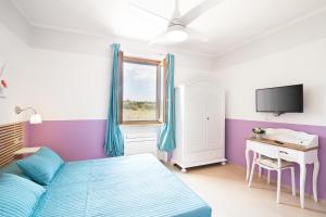 1 dormitorio con 1 cama, escritorio y TV en Apartment in the heart of Maremma, Tuscany, en Alberese