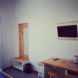 Habitación con escritorio y TV en la pared. en KipoRooms, en Zollino