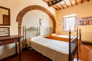 a bedroom with two beds and an archway at Castello di Selvole in Vagliagli