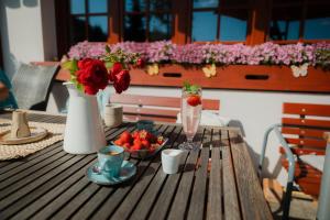 una mesa de madera con un bol de fresas y una bebida en U Sadílků en Paseky nad Jizerou