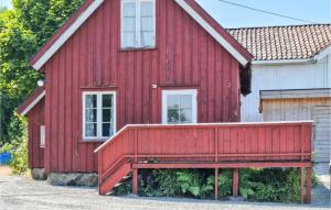una casa roja con un banco delante en Stunning Home In Risr With Kitchen, en Risør