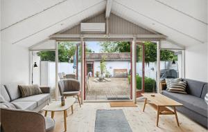 uma sala de estar com um sofá e uma mesa em Cozy Home In Frvang With Outdoor Swimming Pool em Fårvang
