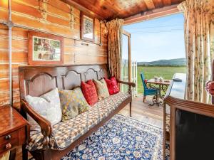 a couch in a room with a porch with a table at Dennis in Llanwnda