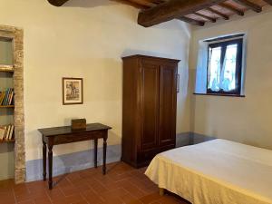 1 dormitorio con 1 cama y armario de madera en Castello di Selvole, en Vagliagli