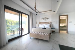 a bedroom with a bed and a large window at ROYAL VIEW VILLAS in Skiathos
