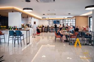 Eine Gruppe von Menschen sitzt an Tischen in einem Restaurant in der Unterkunft Maghrib Hotel in Ulcinj