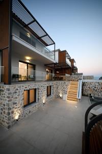 a house with a stone facade with a balcony at ROYAL VIEW VILLAS in Skiathos