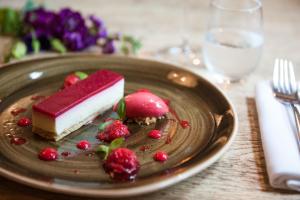 a piece of cake and berries on a plate on a table at The Canford in Poole +36 photos