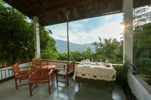 una mesa y sillas en un balcón con vistas en Hilltop Retreat Matale, en Matale