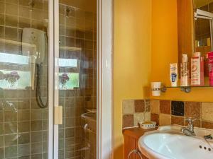 uma casa de banho com um chuveiro e um lavatório. em Yelt Cottage em Wootton
