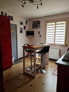 Reffannes的住宿－Chambre privé inclu chez l'habitant，厨房配有桌子和带2张凳子的书桌。
