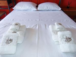 ein Bett mit Handtüchern und gefalteten Handtüchern darauf in der Unterkunft The Orange Cactus in Sparta