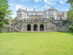 ein großes Schloss mit Treppen auf einem Grasfeld in der Unterkunft Apartment 14, Hazelwood Hall in Silverdale