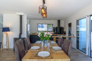une salle à manger avec une table et des chaises ainsi qu'une cuisine dans l'établissement Maison au pied des sentiers côtiers, à Vannes