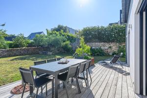 a wooden deck with a table and chairs on it at Maison au pied des sentiers côtiers in Vannes