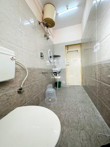 a bathroom with a toilet and a sink in it at VHB Inn in Jigani