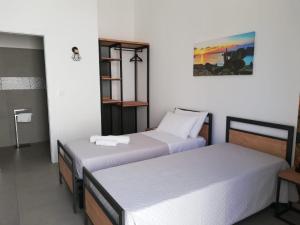 two beds in a room with white walls at KipoRooms in Zollino