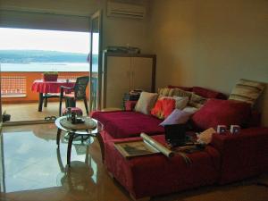 sala de estar con sofá rojo y mesa en AdriaLove, en Crikvenica