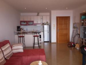 sala de estar con sofá rojo y cocina en AdriaLove, en Crikvenica