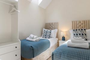 a bedroom with two twin beds with blue sheets at 1 Chapel Mews in Sidmouth