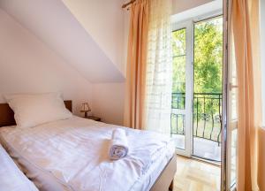 1 dormitorio con cama y ventana grande en Gościniec Jędruś, en Dąbki