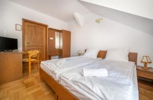 1 dormitorio con 1 cama blanca grande y toallas. en Gościniec Jędruś, en Dąbki