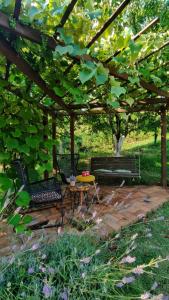 a patio with two chairs and a table under a pergola at RELAX HOME Visoko in Visoko