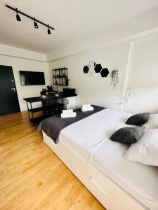 Un dormitorio con una cama blanca grande y un escritorio en Clouds Apartments Čiovo - 20 meters from Copacabana beach, en Trogir