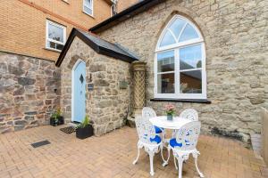 a patio with a table and chairs and a building at 1 Chapel Mews in Sidmouth