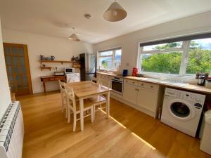a kitchen with a table and a sink and a dishwasher at The Sheiling holiday home with gorgeous views over the isles in Arisaig