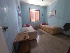 ein kleines Zimmer mit 2 Betten und einem Fenster in der Unterkunft ARGENTARIO PORTO ERCOLE Flat in Porto Ercole