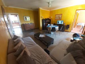 ein Wohnzimmer mit einem Sofa und einem Tisch in der Unterkunft ARGENTARIO PORTO ERCOLE Flat in Porto Ercole