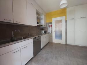 eine Küche mit weißen Schränken und einem Waschbecken in der Unterkunft ARGENTARIO PORTO ERCOLE Flat in Porto Ercole
