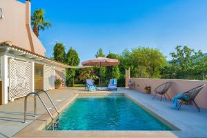 basen z krzesłami i parasolem obok domu w obiekcie Bay Lodge Alykanas w Alikanás