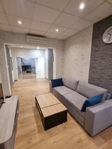 uma sala de estar com um sofá e um relógio na parede em Appartement Centre ville em Chalon-sur-Saône