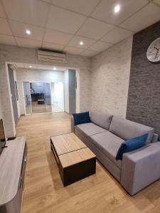 a living room with a couch and a clock on the wall at Appartement Centre ville in Chalon-sur-Saône