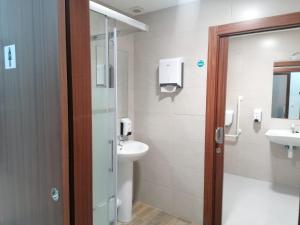 uma casa de banho com um lavatório e um WC em Albergue El Templarin em Ponferrada
