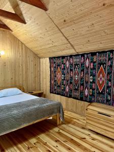 1 dormitorio con 1 cama en una habitación con paredes de madera en Girskiy Prutets, en Bukovel