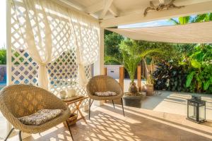 dwa krzesła i stół na ganku z płotem w obiekcie Bay Lodge Alykanas w Alikanás
