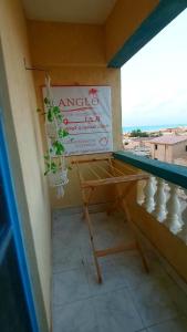 Un balcón con una mesa y una planta. en Anglo Chalets - Ageeba beach en Marsa Matruh