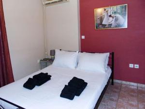 1 dormitorio con 1 cama con 2 toallas negras en Urban Stay, en Esparta